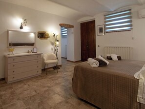 Ein Schlafzimmer mit Bett, Schminktisch, Stuhl und Spiegel.