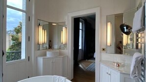 A modern bathroom with a freestanding bathtub, a large mirror, and a walk-in shower. - Villa Gabriel Maison Blanche Chartres (Chartres)