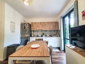 A modern kitchen with wooden cabinets, a stainless steel refrigerator, and a dining table with chairs. - Nice apartment for 2 people with A/C, WIFI, private pool, TV and terrace (Termini Imerese)