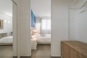 Ein modernes Hotelzimmer mit Bett, Nachttisch und einem Holzschrank.