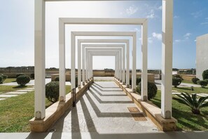 A pathway with white pillars leading to a distant view. - Venti di Laguna Apartments Stagnone - Tramontana (Marsala)