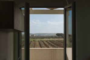 A room with a large window overlooking a vineyard. - Venti di Laguna Apartments Stagnone - Tramontana (Marsala)