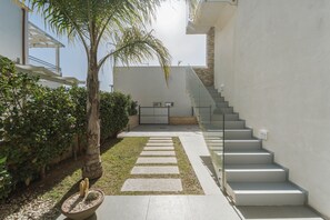 A modern outdoor area with a staircase, a palm tree, and a potted plant. - Venti di Laguna Apartments Stagnone - Ponente (Marsala)
