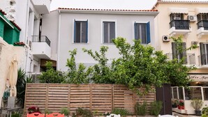 Een gebouw met een witte gevel, houten luiken en een balkon met een zwarte balustrade.