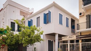 A two-story building with blue shutters, a balcony, and a sign for 'Káru Afo' restaurant. - Gytheio Charming Studio - Steps Away From the Sea (East Mani)