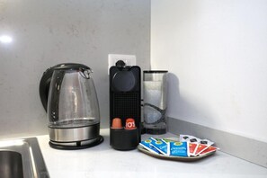 Eine Küche mit Kaffeemaschine, Wasserspender und einer Kaffeekapseln.