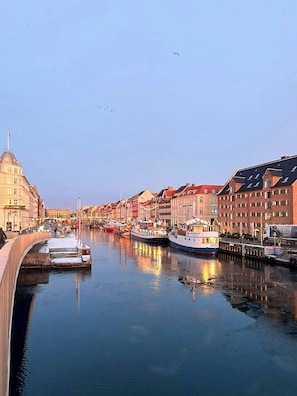 Un canal con barcos, un puente y edificios históricos a lo largo del agua.