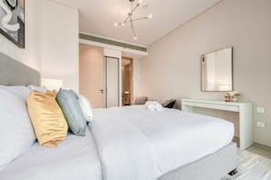 Ein modernes Hotelzimmer mit einem großen Bett, einem Schreibtisch und einem Spiegel.