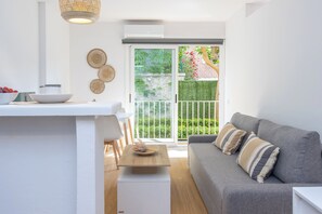 Ein zeitgemäßer Wohnraum mit Sofa, Esstisch und Küchenzeile.