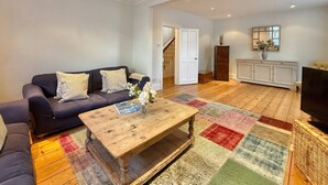 Ein Wohnzimmer mit einer Couch, einem Couchtisch und einem Fernseher.