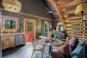 Ein gemütliches Blockhaus-Interieur mit Küche, Essbereich und einer Treppe.