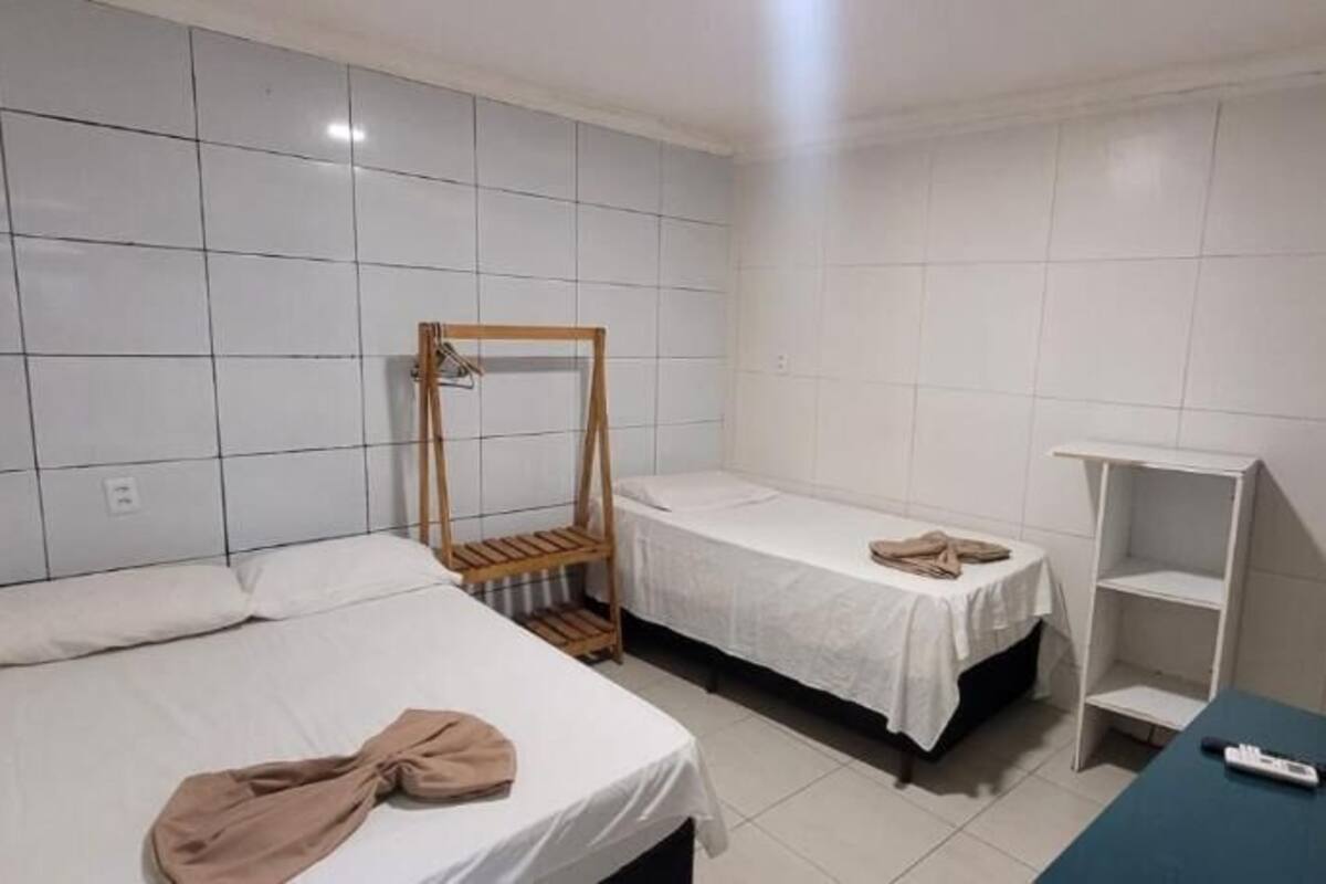 A room with two beds, a wooden ladder, a small table, and a TV.