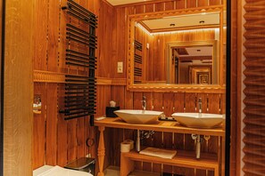 A wooden bathroom with two sinks, a mirror, and a towel rack. - Mountain Diamond Resort (Zakopane)
