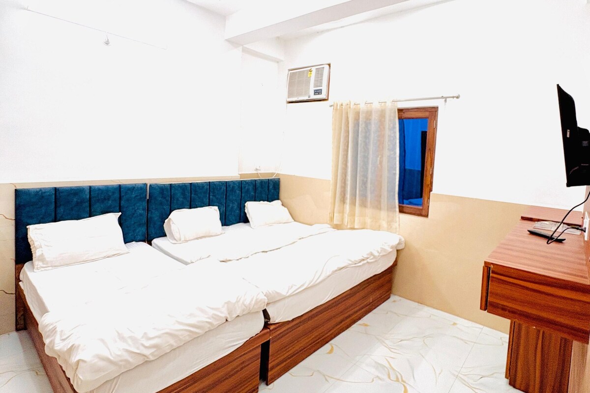 Une chambre à coucher avec un lit, un bureau, un ventilateur de plafond et une fenêtre avec des rideaux.