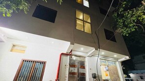 A building with a door, windows, and a visible pipe. - Hotel Vrinda Nikunj Dham (Vrindavan)