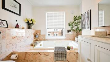 Kombinasi shower/bathtub, bathtub besar, dan handuk