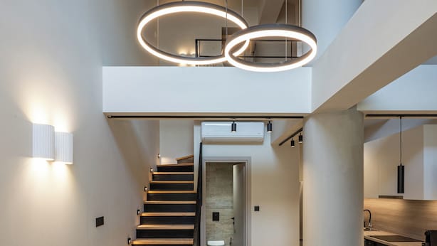 A modern interior with a staircase, a sofa, and a dining area. - Elmar Urban Living (Chania)