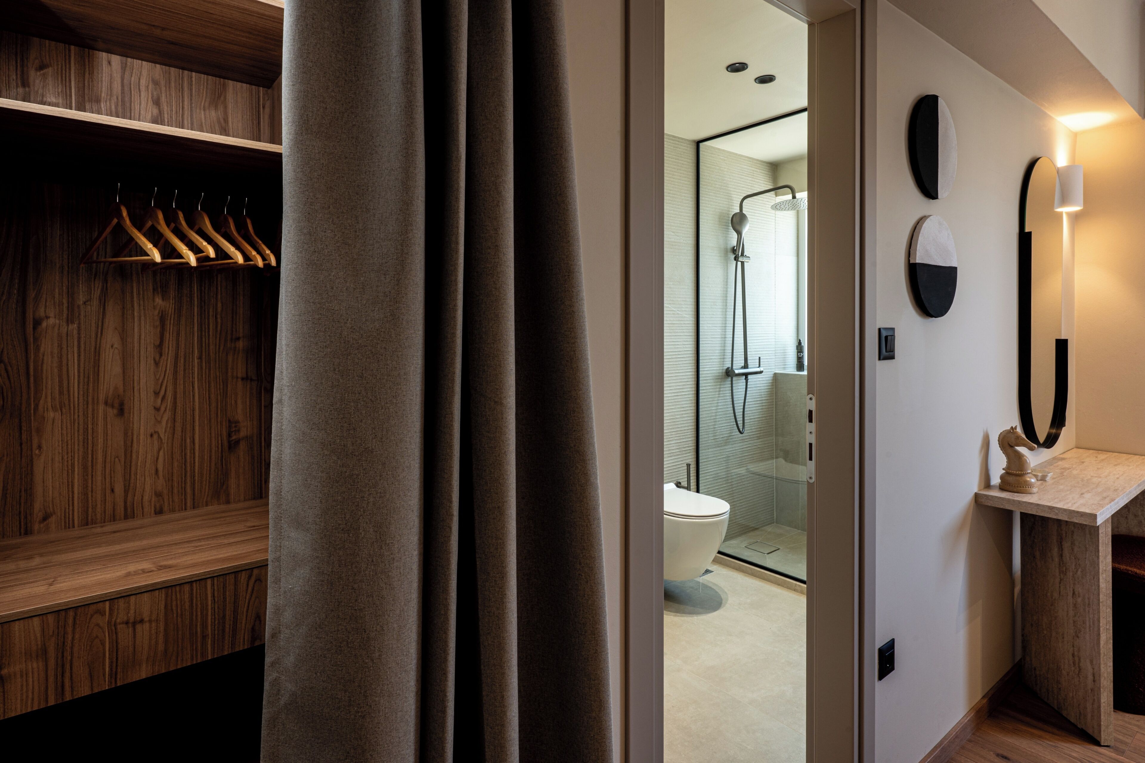 A modern bathroom with a shower, toilet, and a wooden vanity with a mirror.