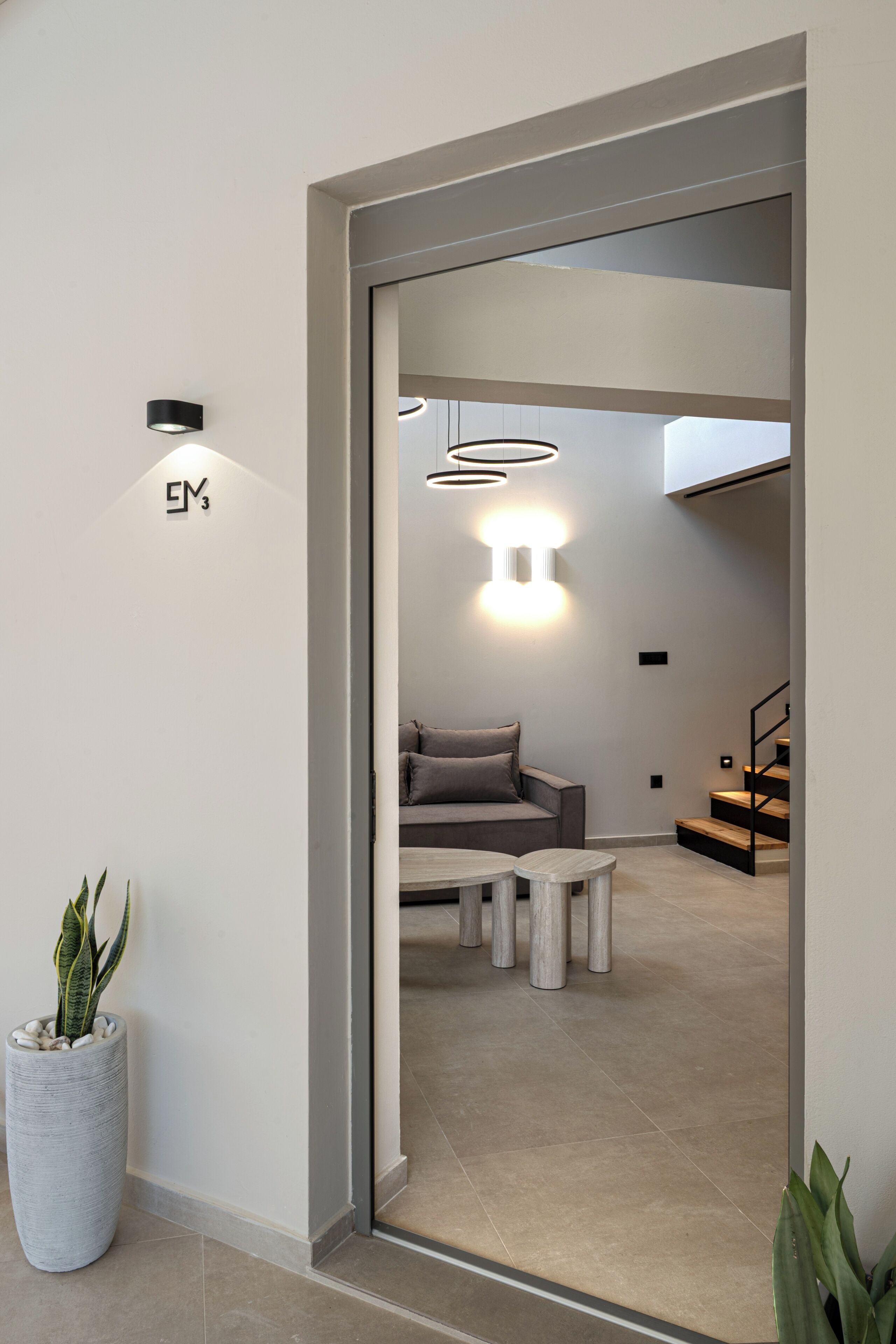 A modern interior with a sofa, coffee table, and a staircase.