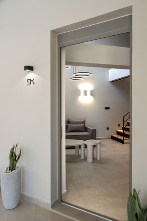 A modern interior with a sofa, coffee table, and a staircase.