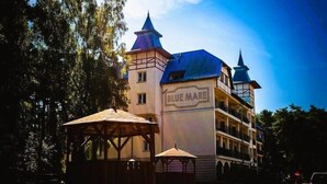 A building with a sign reading 'BLUE MARE,' a large structure with multiple floors, and a tower-like feature. - Apartment with swimming pool, Lukecin (Łukęcin)