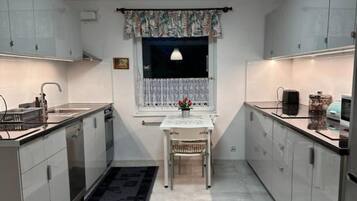 Cocina compacta con ventana, una mesa de comedor y una silla.