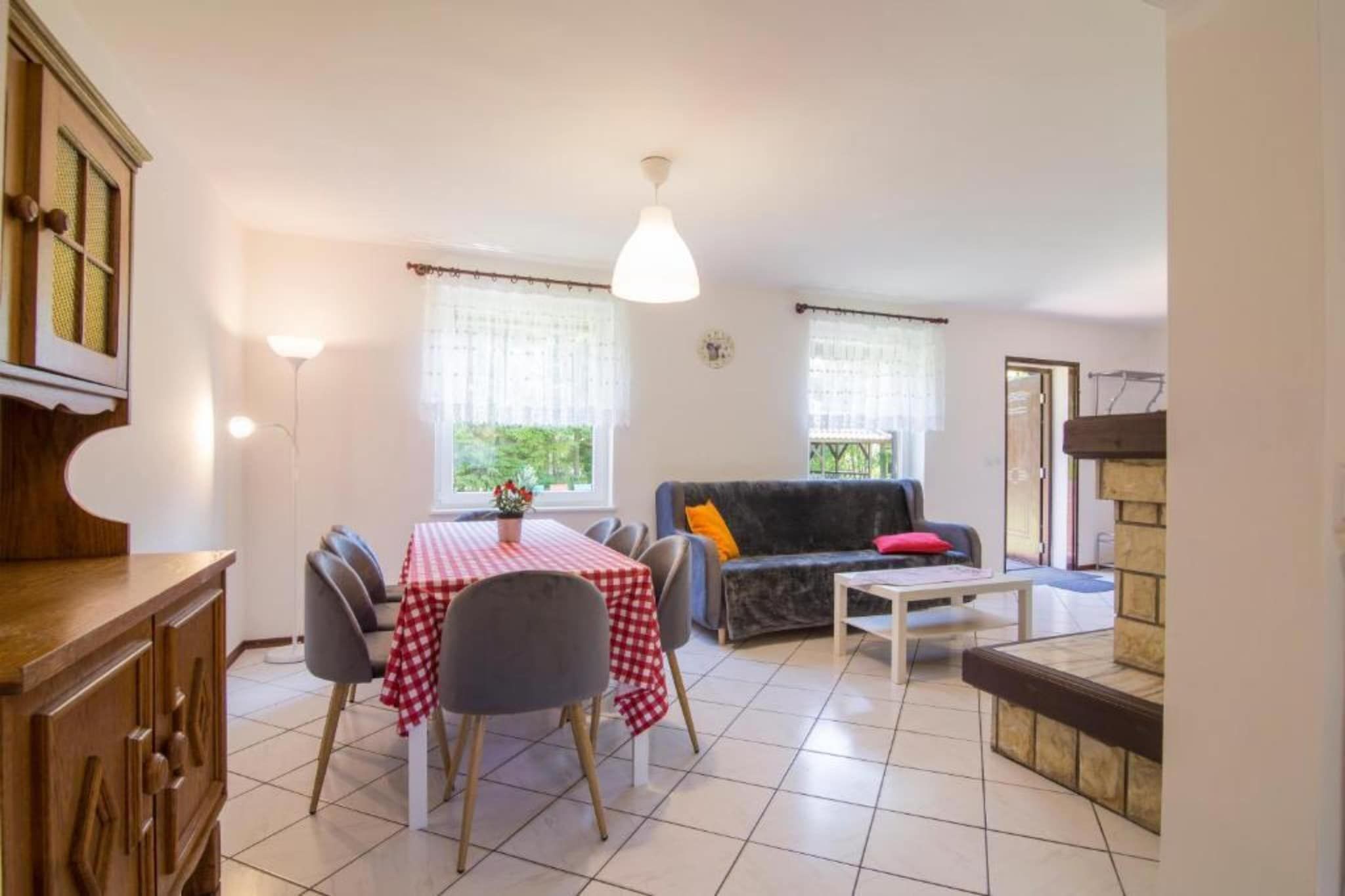A dining area with a table set for four, a sofa, and a small coffee table.