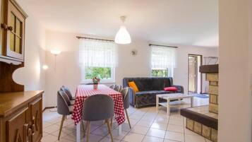 A dining area with a table set for four, a sofa, and a small coffee table.