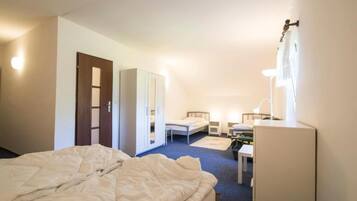 Une chambre d’hôtel comprenant un lit, un bureau, une chaise, une armoire et un miroir.