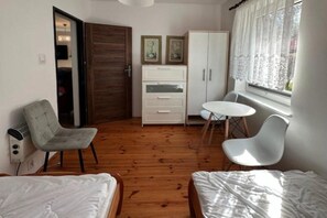 A compact room with a bed, a desk, a chair, and a wardrobe.