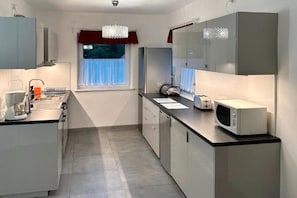 A modern kitchen with a microwave, toaster, and coffee maker. - Comfortable holiday villa with a private garden (Lubiatowo)