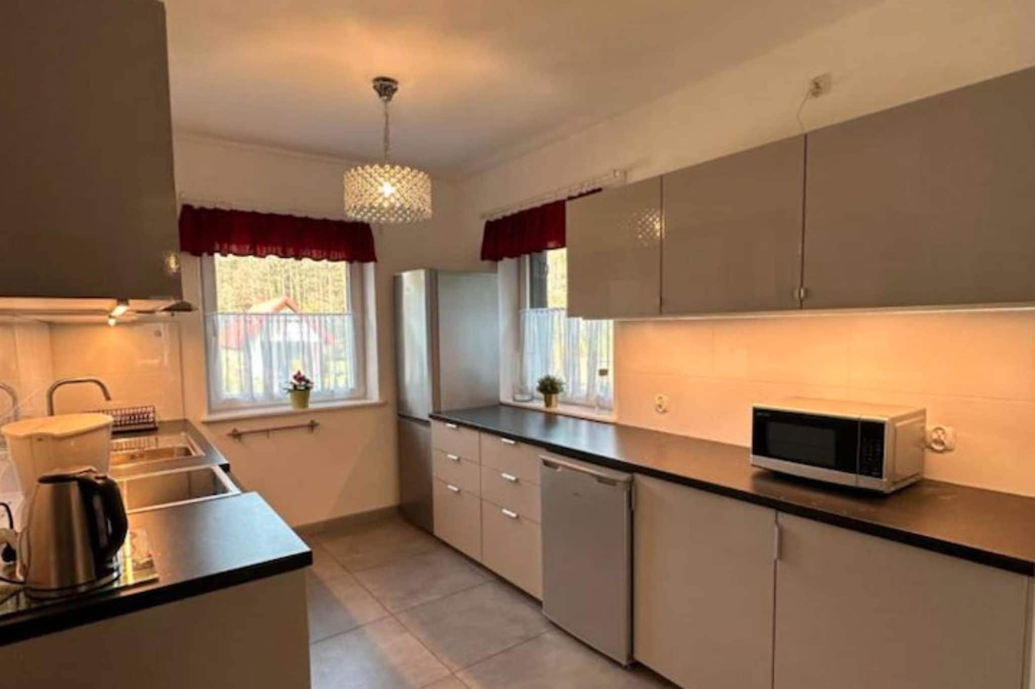 A kitchen with a microwave, cabinets, and a sink.