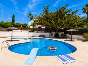 A swimming pool with a lifebuoy, a ladder, and a bench. - House With Garden & Beach (Orihuela)