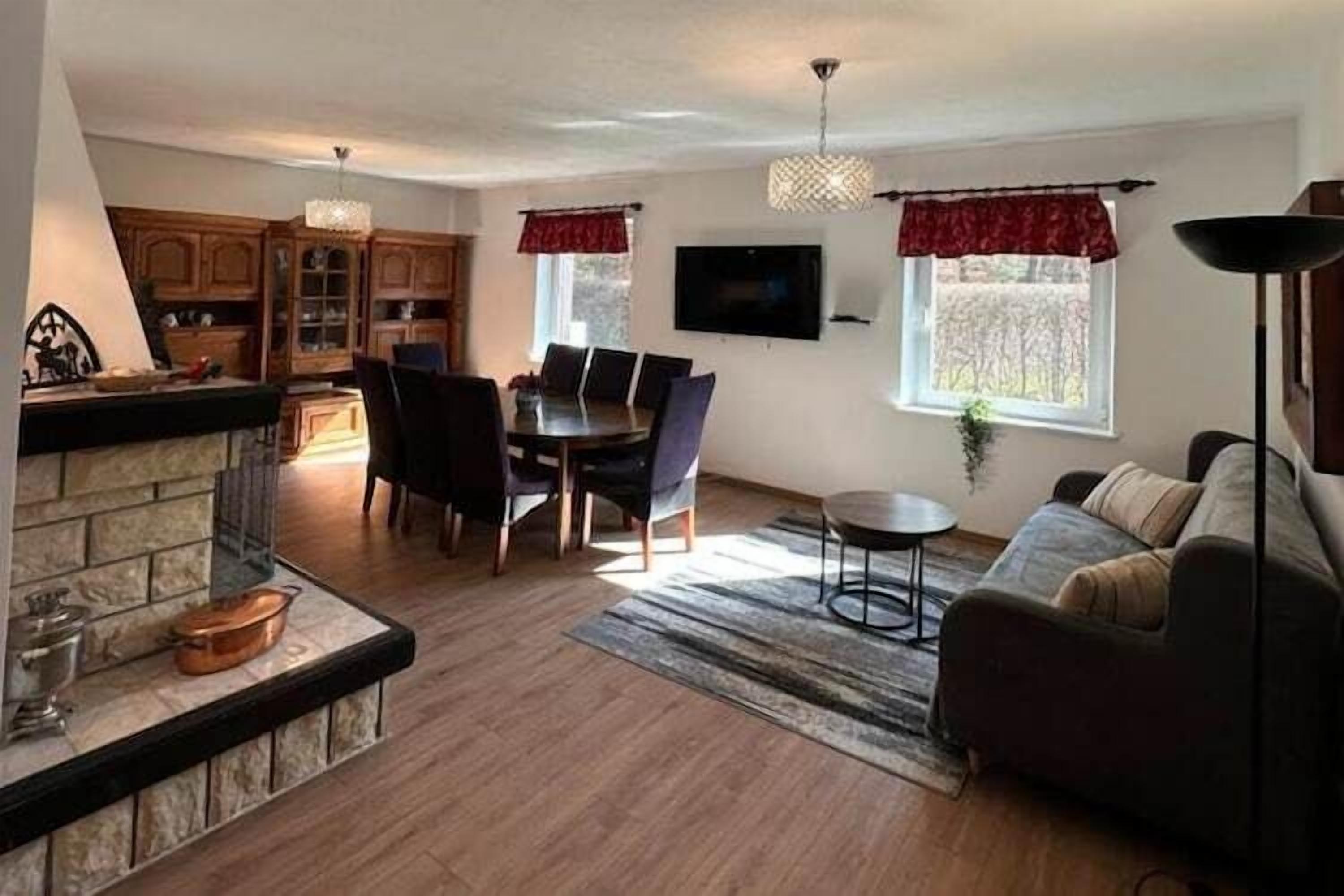 Un salon avec une cheminée, un coin repas et un canapé.