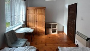 A small room with two beds, a wooden wardrobe, a table, and a chair. - Large and comfortable holiday villa with a garden (Lubiatowo)