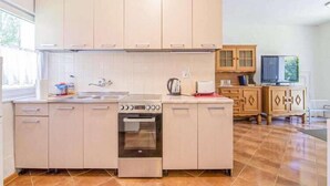 Una cocina moderna con una isla central, horno empotrado y un ventanal que proporciona luz natural.