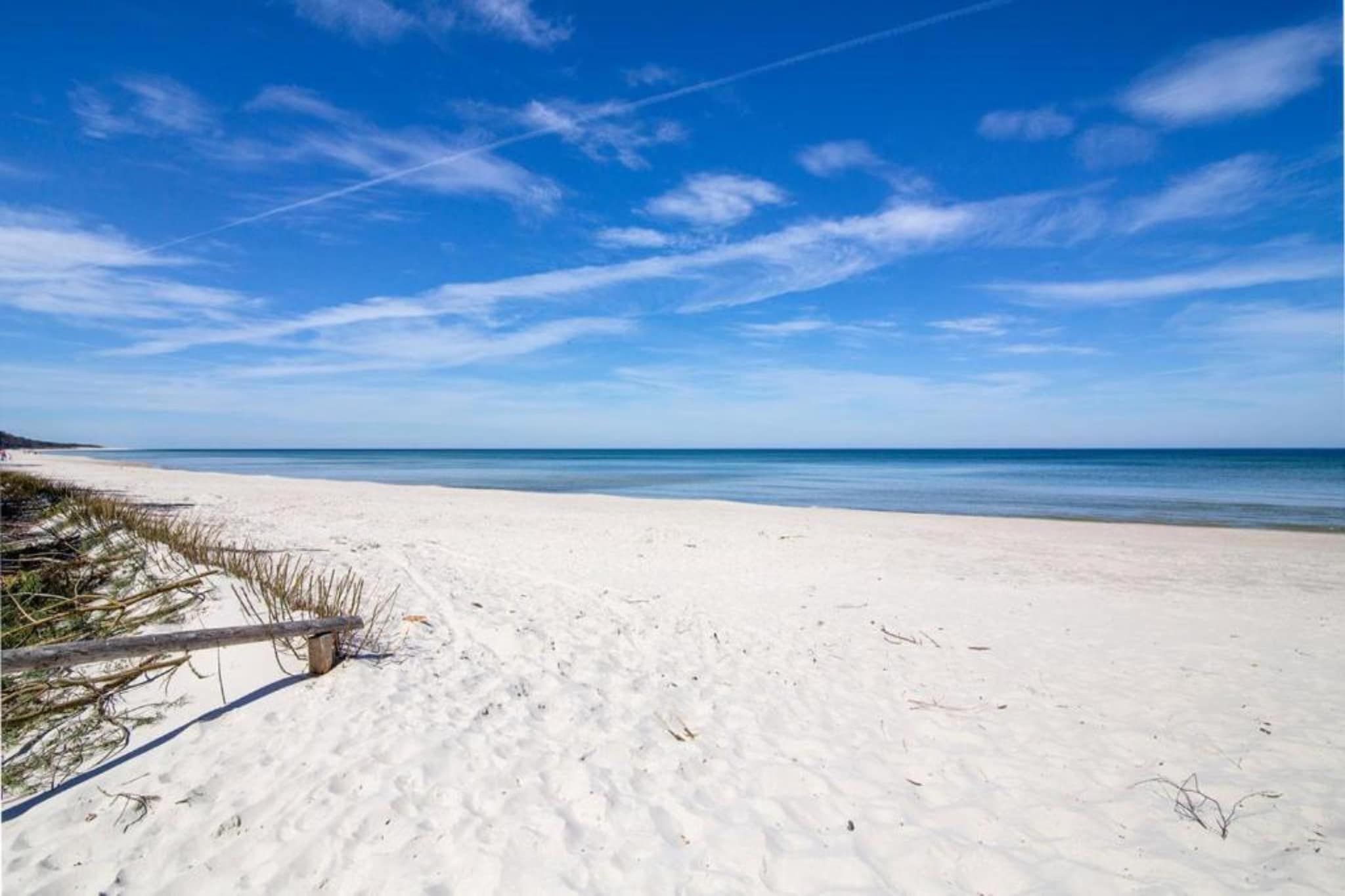 Une plage de sable blanc, sous un ciel bleu azur.