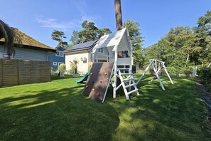 Ein Spielbereich mit einer Kletterwand und einer Schaukel.