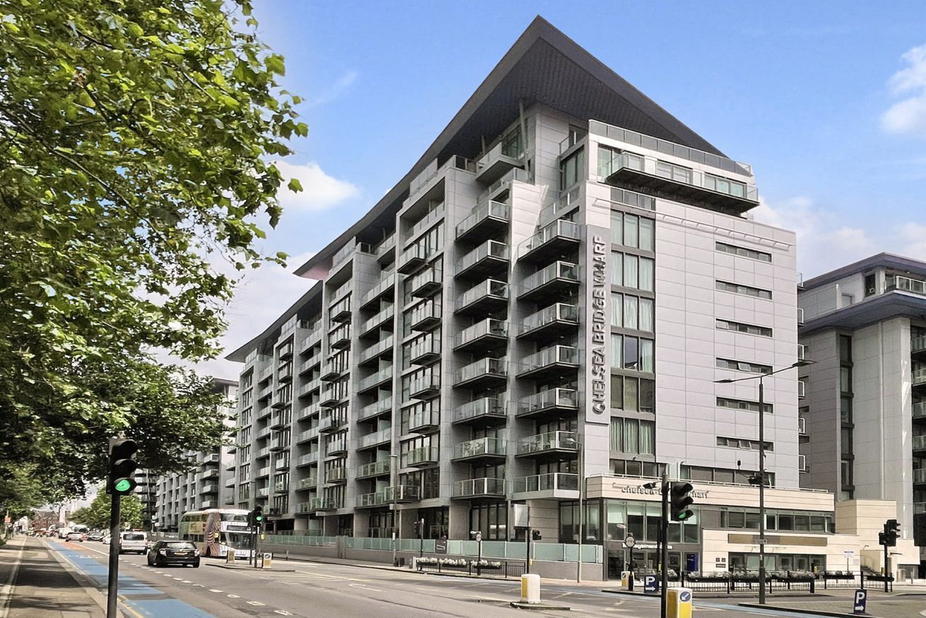A multi-story building with a modern architectural design, featuring balconies and large windows.
