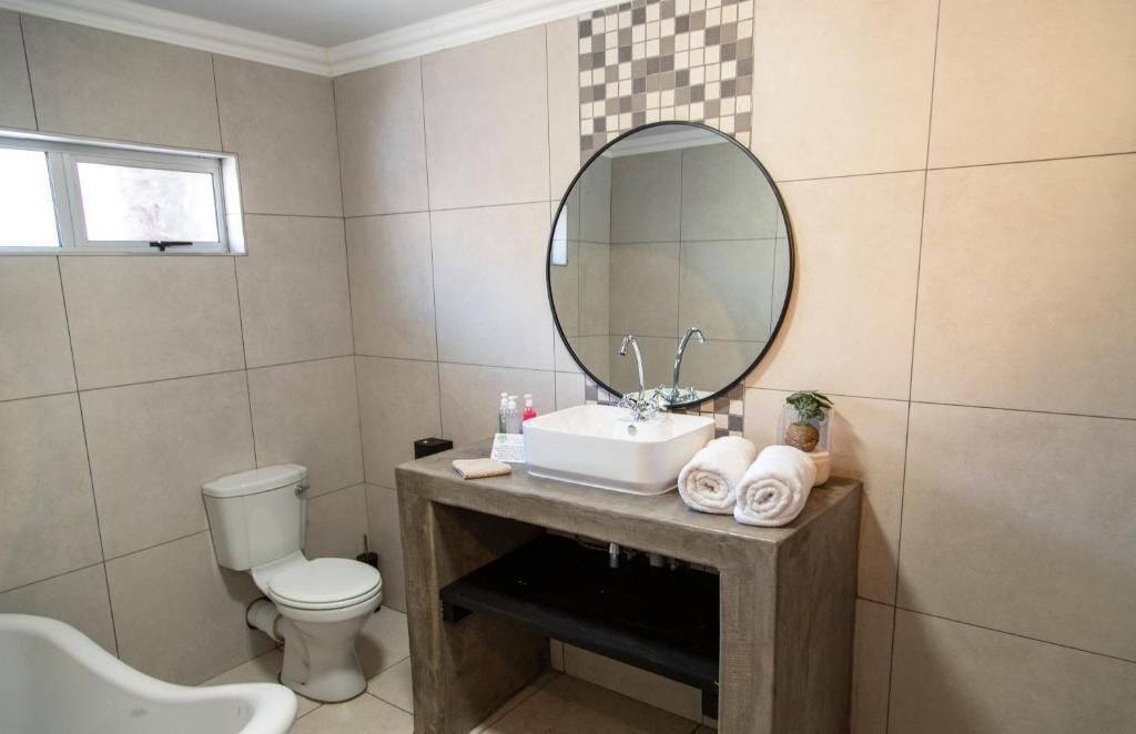 A bathroom with a toilet, sink, and bathtub.