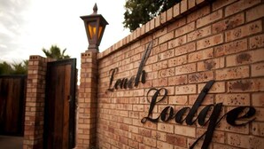 A brick wall with the words 'Linch Lodge' in a decorative font.