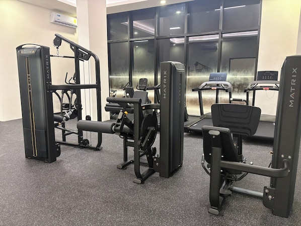 A gym with various exercise equipment, including a squat rack, bench press, and treadmills. - San Francisco Cancun (Cancun)