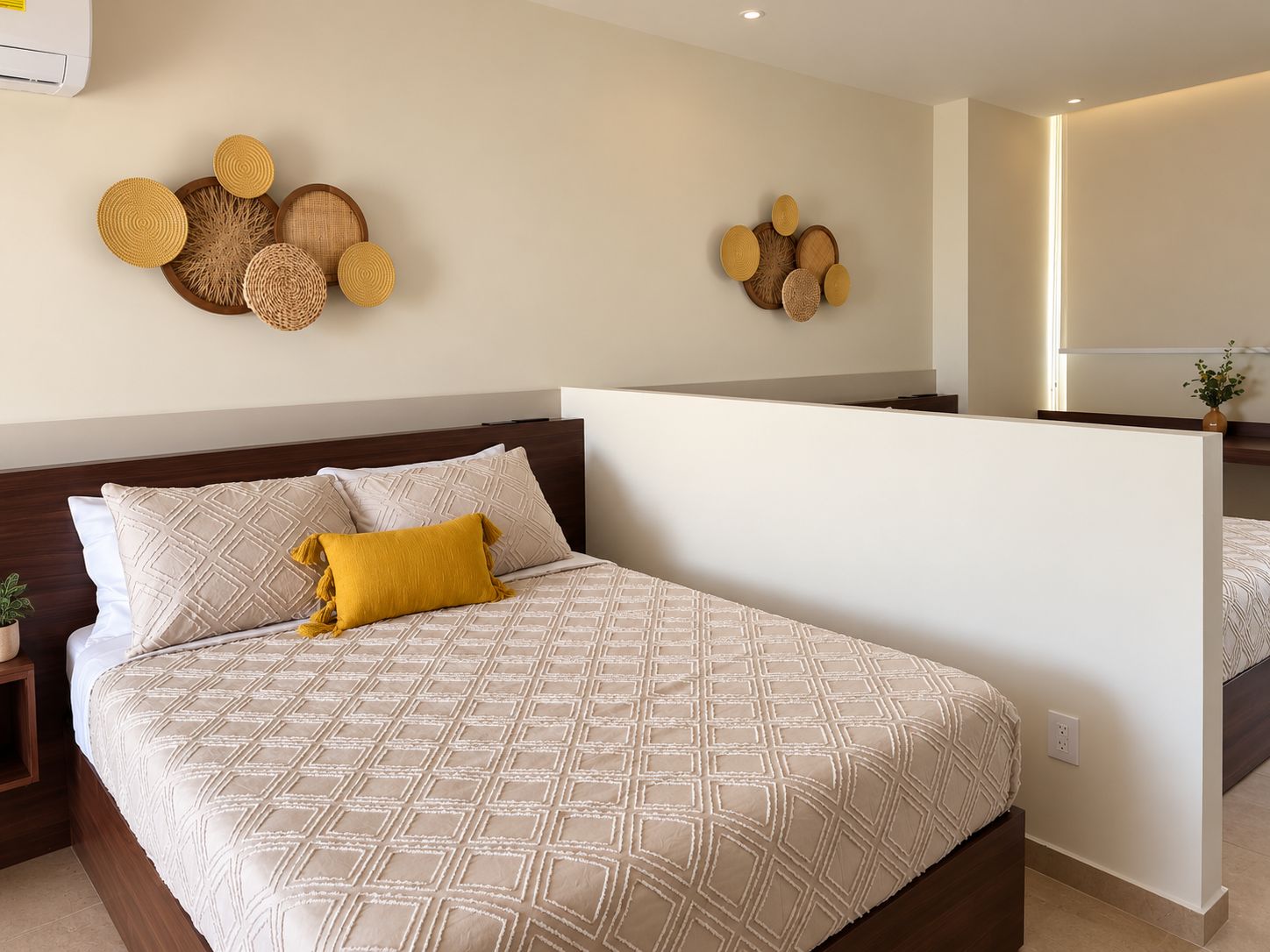 A hotel room with a bed, a nightstand, a mirror, and wall decor.