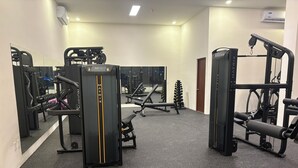 A gym with various exercise equipment, including weight machines and free weights. - San Francisco Cancun (Cancun)
