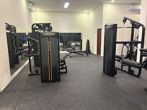 A gym with various exercise equipment, including weight machines and free weights. - San Francisco Cancun (Cancun)
