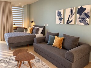 A modern bedroom with a bed, a sofa, a desk, and a lamp. - San Francisco Cancun (Cancun)