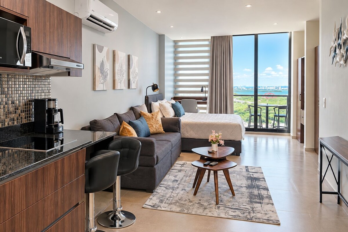 A modern living room with a sofa, a coffee table, and a view of the outdoors.