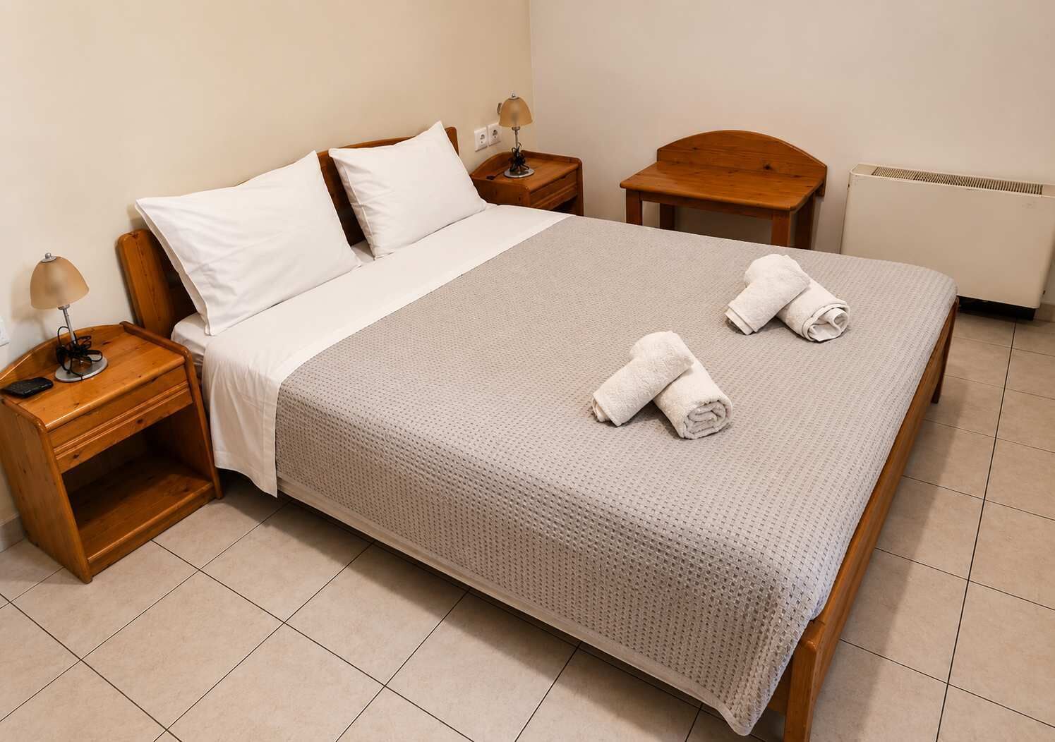 Cozy bedroom with fresh linens, wooden furniture, and a calm atmosphere. Ideal for couples or solo travelers seeking a peaceful and comfortable stay close to local attractions and beaches