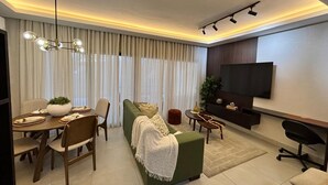 A modern living room with a sofa, dining table, and TV. - Exclusivo zona A (Santiago de los Caballeros)