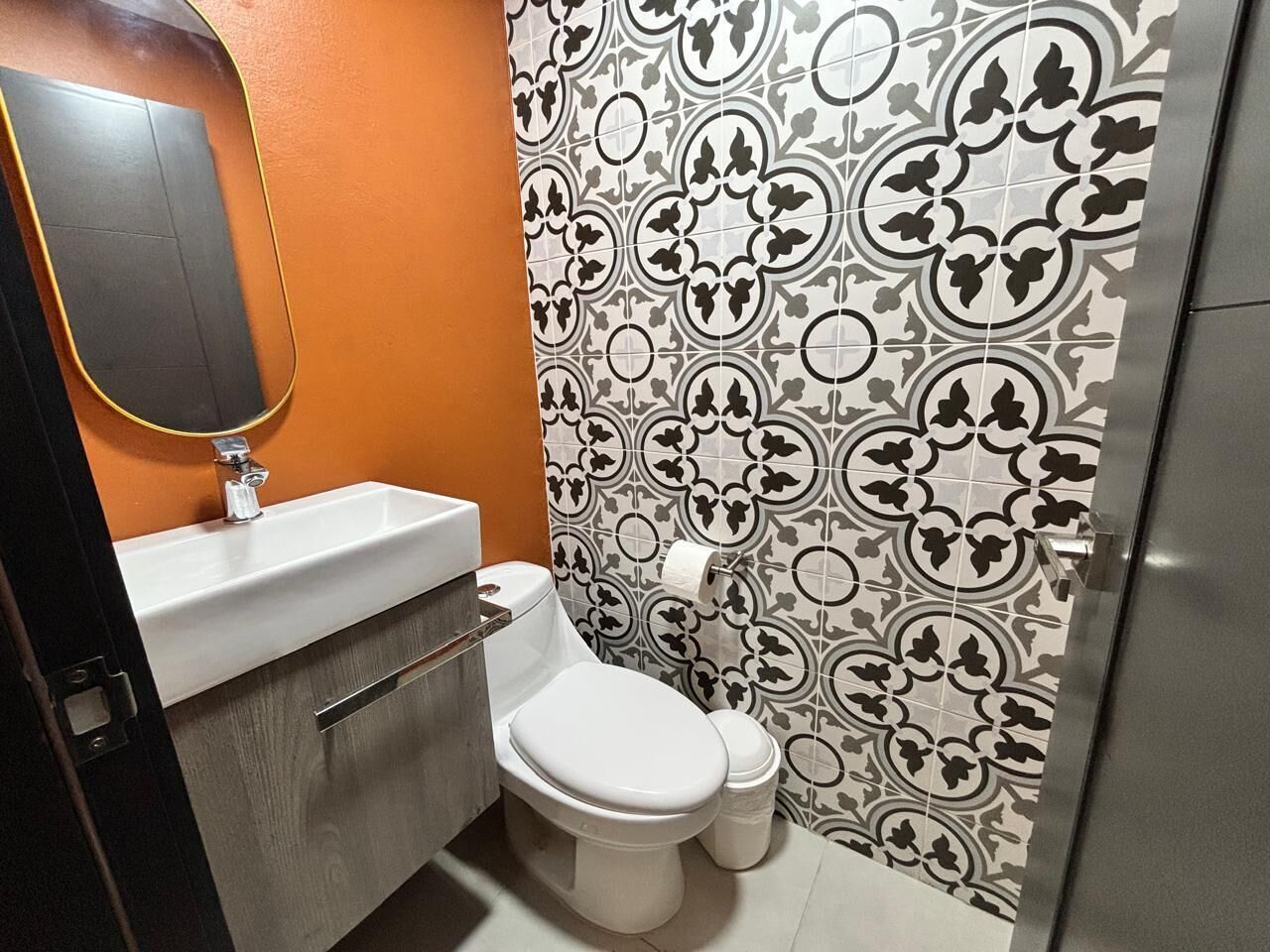 Een badkamer met toilet, wastafel en spiegel.